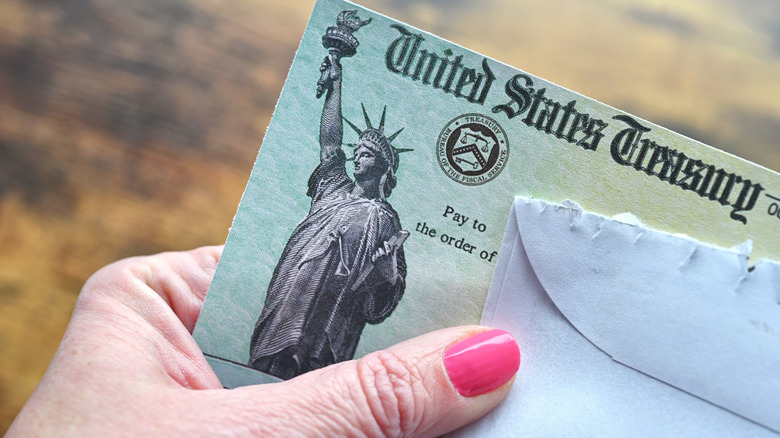 Hand holding an envelope with Social Security check
