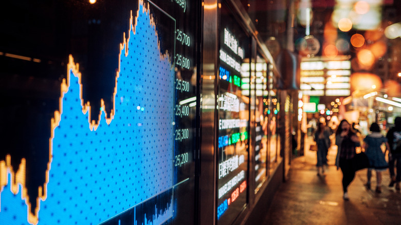 stock market chart on screen facing a pedestrian walkway