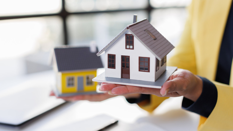 Hand holding a house figurine