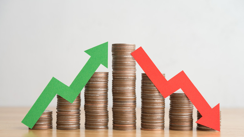 Green and red flow chart arrows over a stack of coins