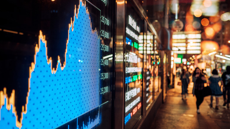 A digital display of a stock market chart displayed to an outdoor street.