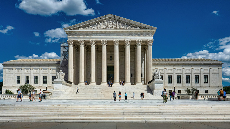 photo of U.S Supreme Court with people standing littered in front