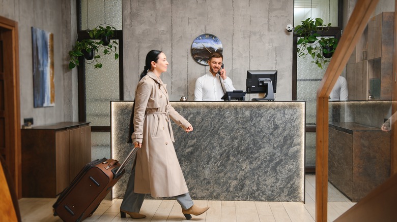Woman with luggage walking in hotel lobby