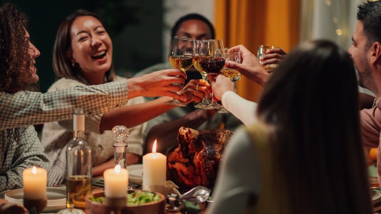 friends offer a toast over a turkey dinner
