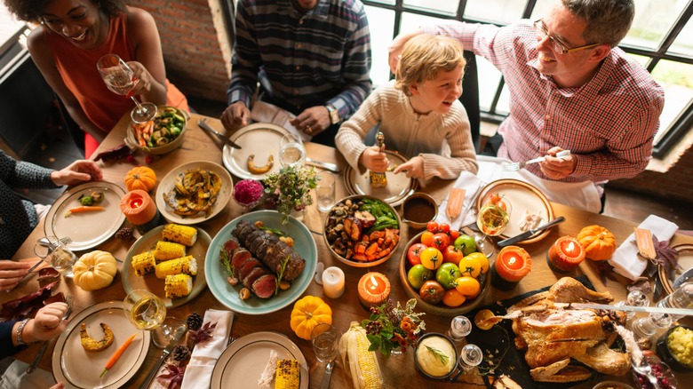 family sitting at table with turkey dinner