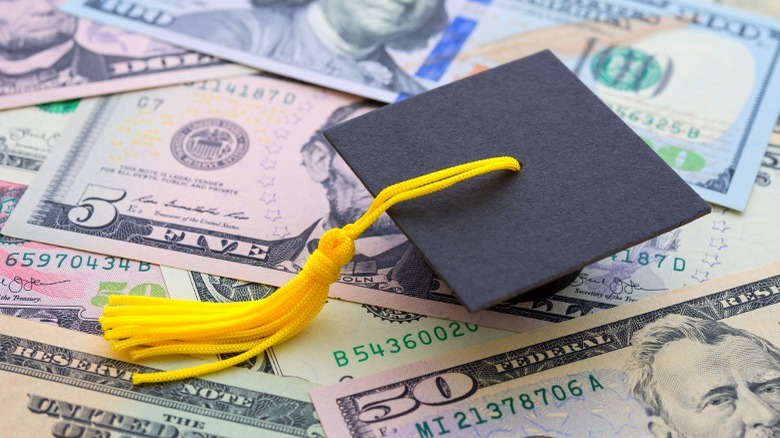 Graduation cap resting on currency