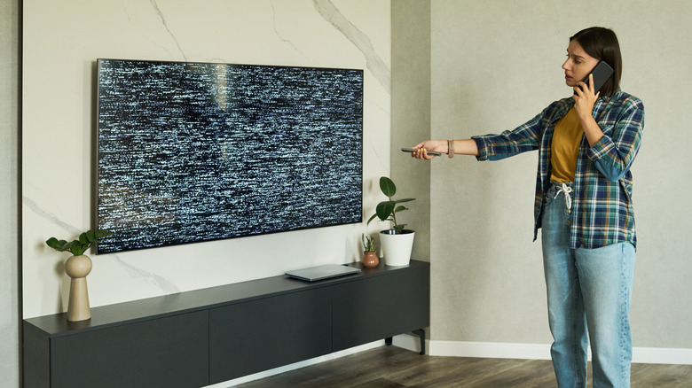 Woman trying to troubleshoot a television's operation