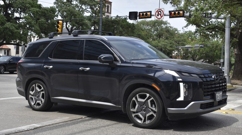 A black Hyundai Palisade SE traveling though moderate traffic.