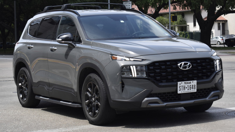 A grey Hyundai Santa Fe SUV driving on the road.