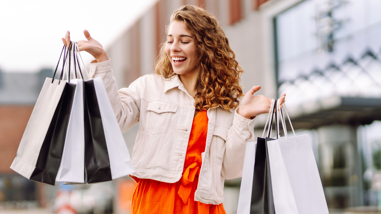 woman smiling and holding shopping bags
