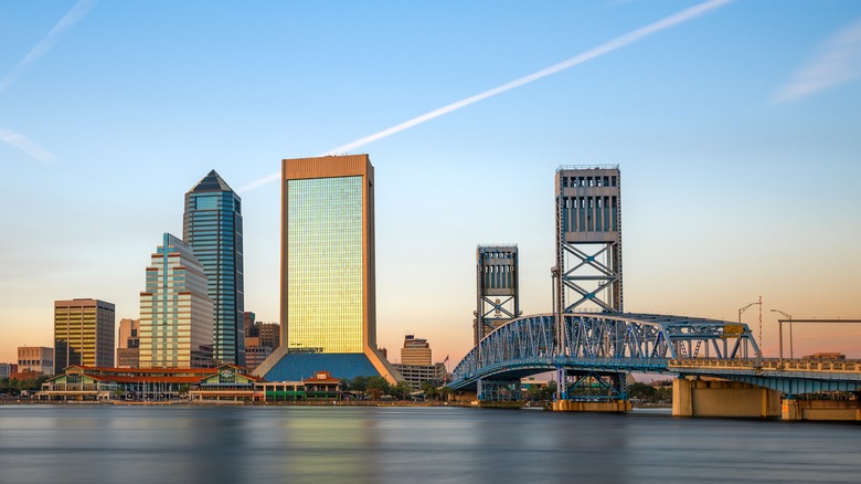 sun reflecting on buildings and blue bridge
