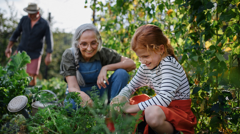 woman and young girl squatting in garden