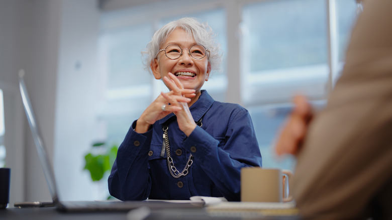 a senior in an office smiling