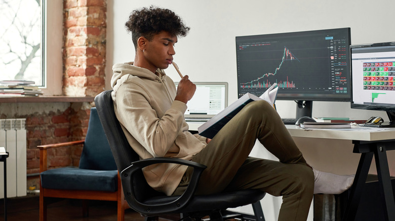 a young investor in front of charts on a computer