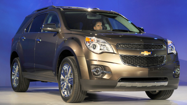 A man sits inside a brown 2010 Chevrolet Equinox at the Detroit International Auto Show