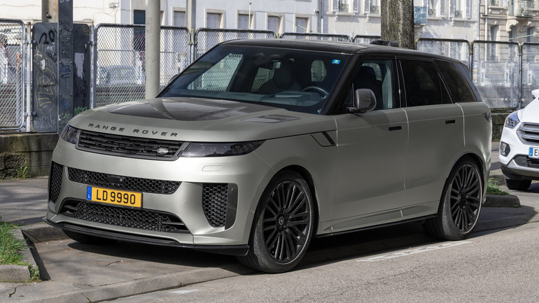A matte beige Land Rover Range Rover Sport SV finished in Ethereal Frost Silver parked on a street.