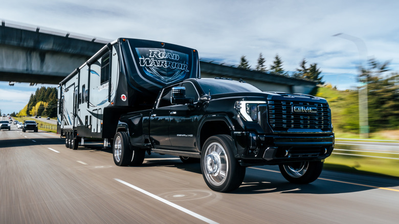 A GMC Sierra 2500 towing a trailer on the highway.