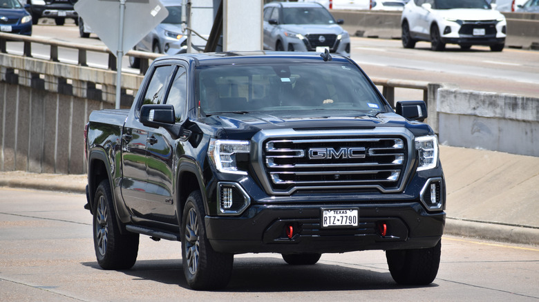 white GMC Sierra 3500 HD pick-up truck traveling down a highway.