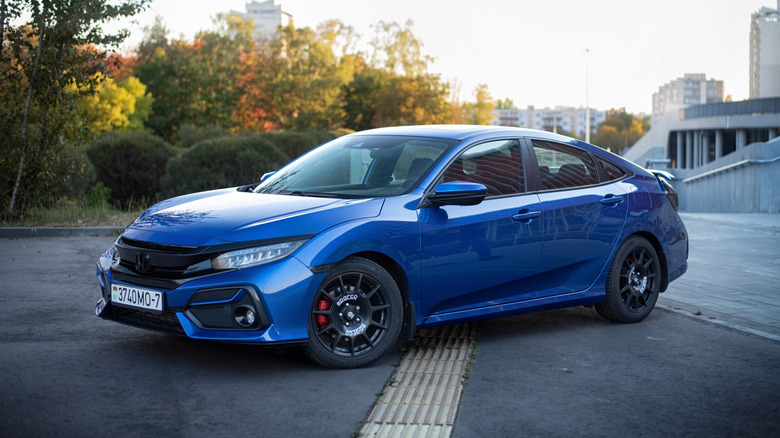 A blue Honda Civic Si turning on a road.