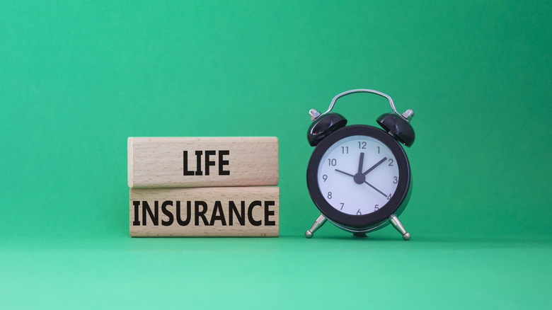 life insurance on blocks next to clock