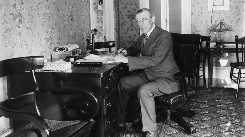 Woodrow Wilson is shown working at his desk.