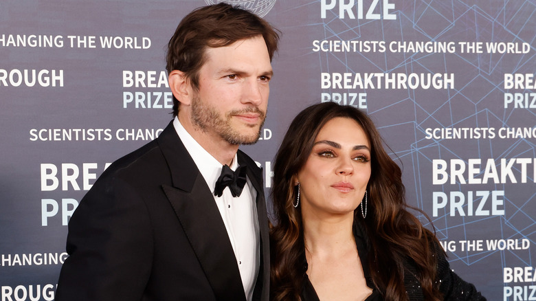 Ashton Kutcher and Mila Kunis posing on a red carpet.