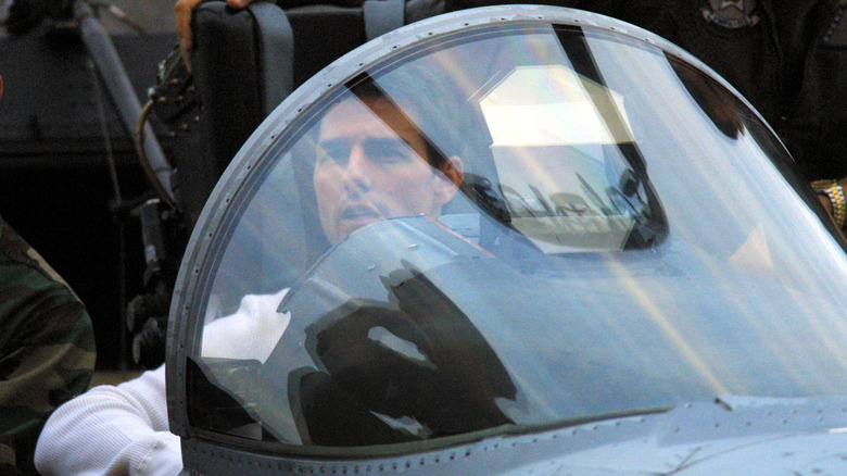 Tom Cruise sitting in a jet cockpit.