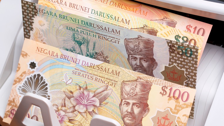 Brunei Dollar banknotes in a money counting machine.