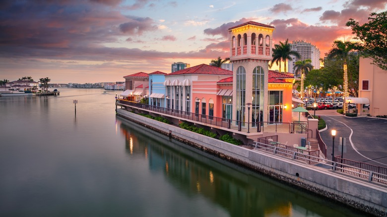 Cityscape image of Naples, Florida with reflection of the city skyline in the water at beautiful sunset