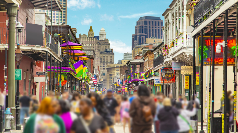 Crowds of people bustle along Bourbon Street in New Orleans, Louisiana