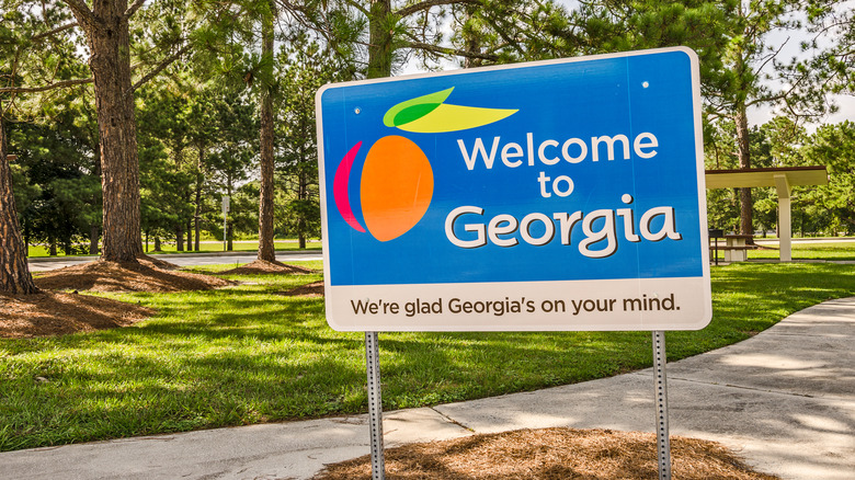 State sign for Georgia welcomes visitors in a shaded rest area.