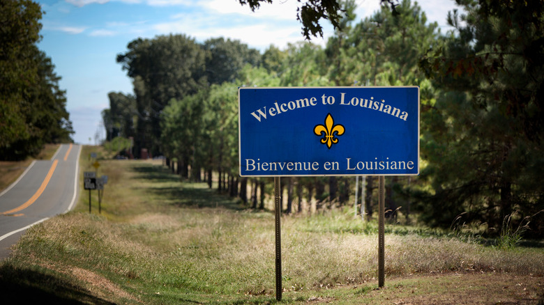 Remote location state line from Texas to Louisiana on a two-lane highway with a sign welcoming travelers into the state of Louisiana.
