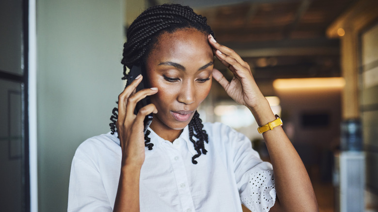 Women with worried look making a phone call.