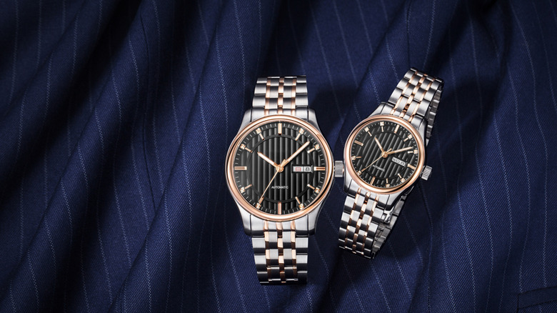 A display of two men's and women's silver mechanical luxury brand wristwatch