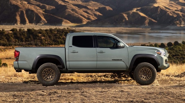 A grey Toyota Tacoma truck parked near a lake