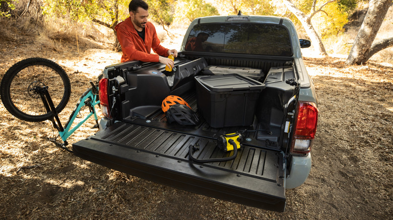 A man unloading a bicycle from a pickup truck bed