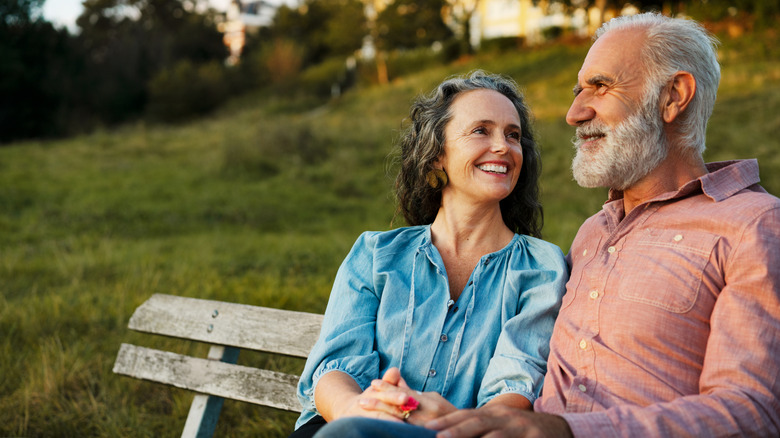 a retired couple sitting on a bench