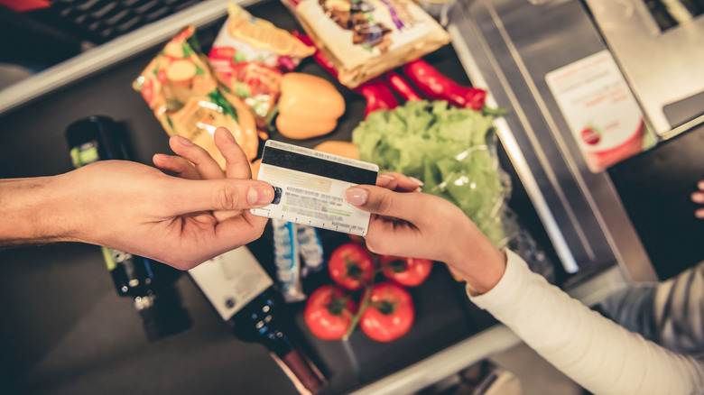 Hands paying for groceries