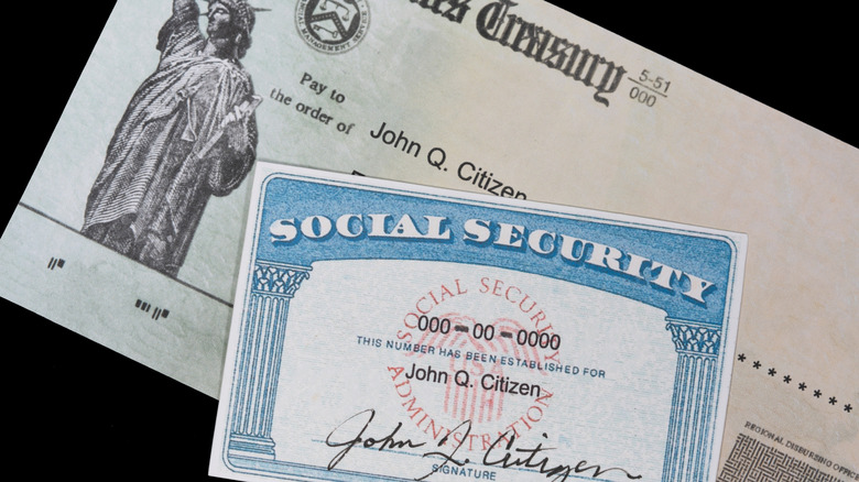 Social Security card and check on black background