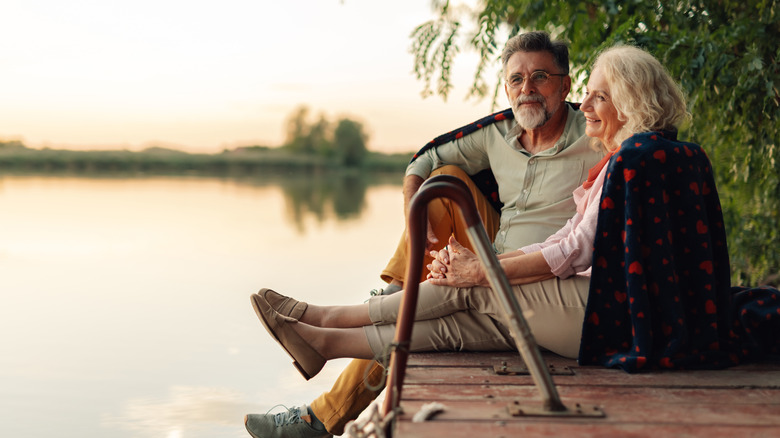 retirees sitting by the water smiling