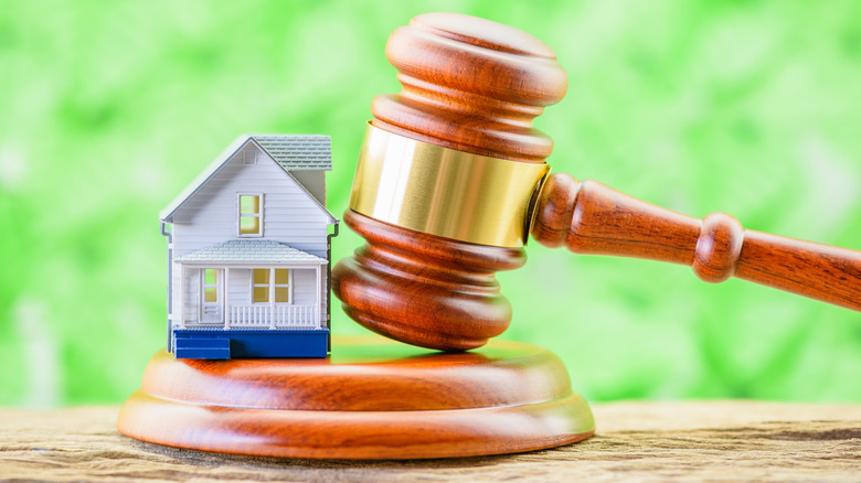 gavel beside a house figurine