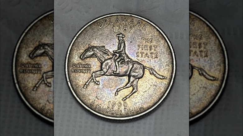 A 1999 Delaware state quarter with a golden hue