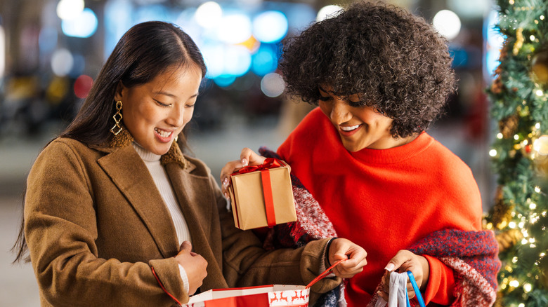 Person holding shopping bags full of Christmas gifts