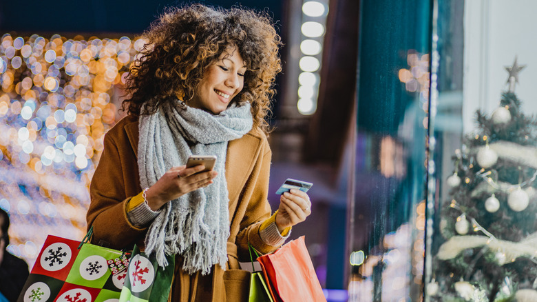 Woman buying presents looking at credit card