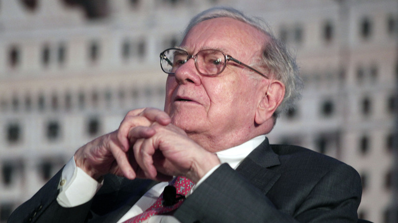 Warren Buffett leaning back at a press event