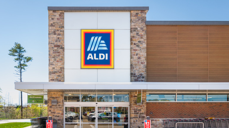 Parking lot reflections in the glass front entrance door of and Aldi Supermarket in Southeastern Massachusetts