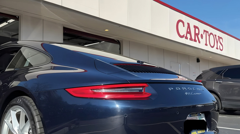 A Porsche 911 parked outside a Car Toys Inc. store