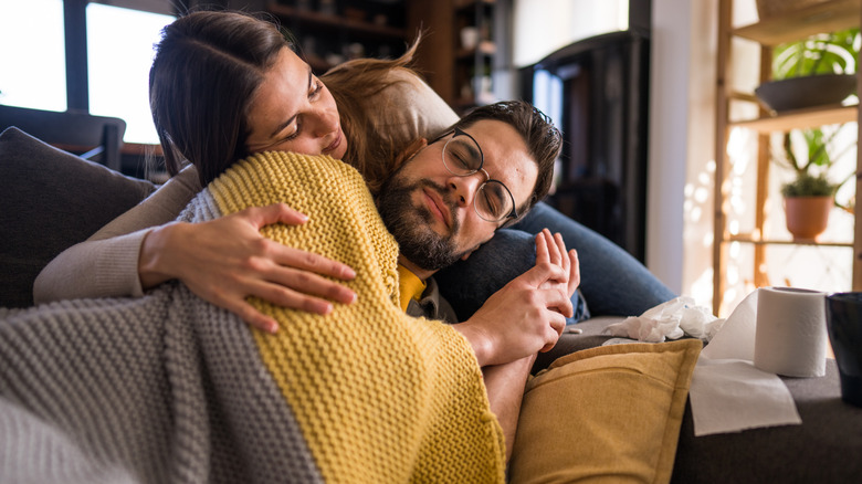 Man with blanket cuddling on the lap of a woman