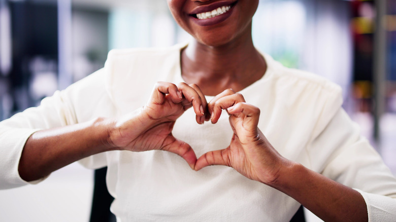 Women with hands in shape of heart