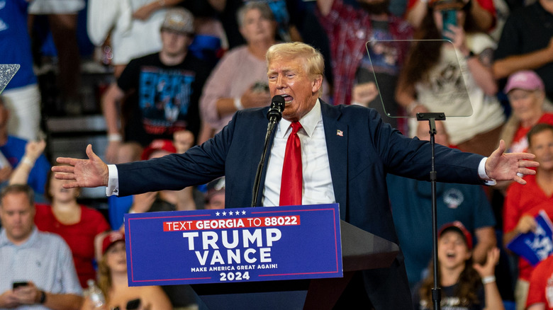 Donald Trump onstage speaking to a crowd of supporters.